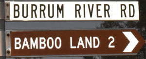 Brown sign for Bamboo Land, 2km, and white side for Burrum River Rd
