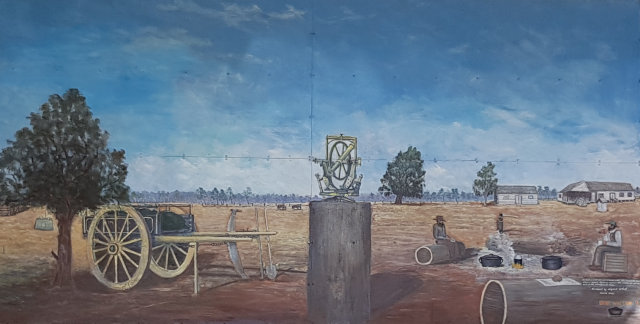 A mural at the Black Stump at Blackall depicting surveying apparatus on a stump by local artist Bob Wilson was made in 1993
