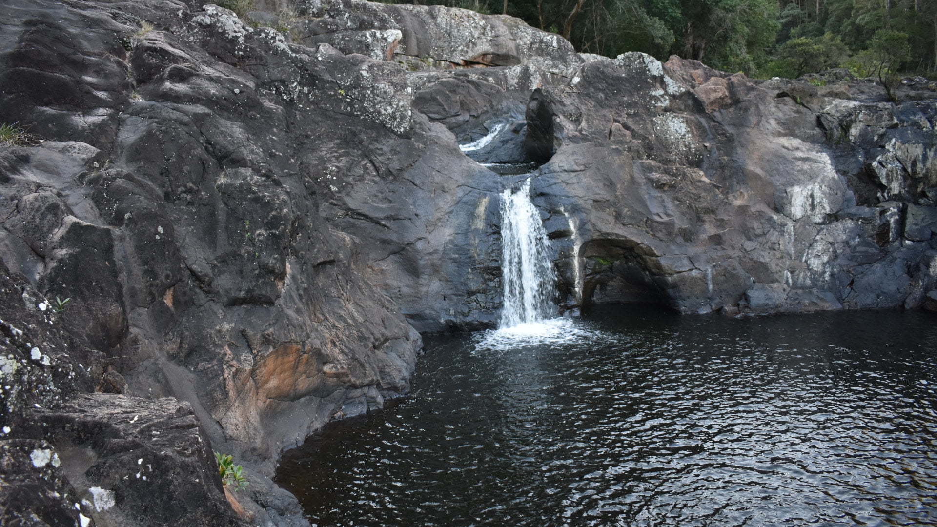 Waterfall cascading from the middle of the rocks into a waterhole, Wappa Falls downstream from Wappa Dam at Yandina