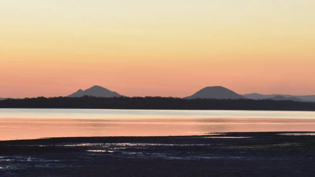 Sunset over water passage with mountains in the background, from Poverty Point on Bribie Island looking towards the Glasshouse Mountains