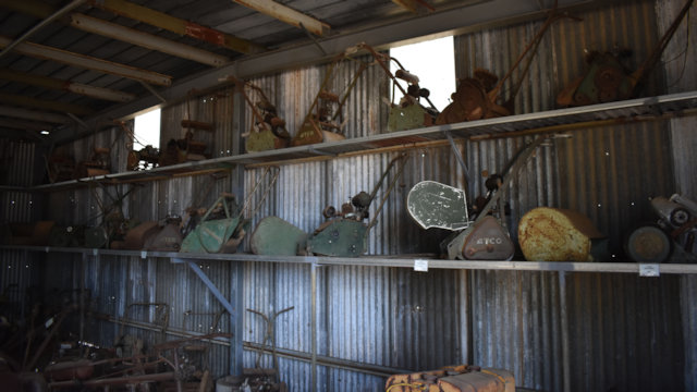 Shed with old motorised roller mowers on the shed wall, at the Mystery Craters near Bundaberg