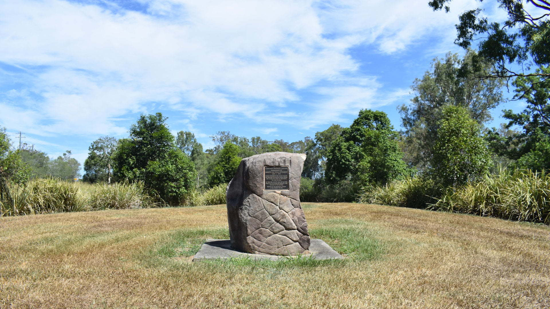 Stone monument in a grass field, at the Captain Logan Memorial