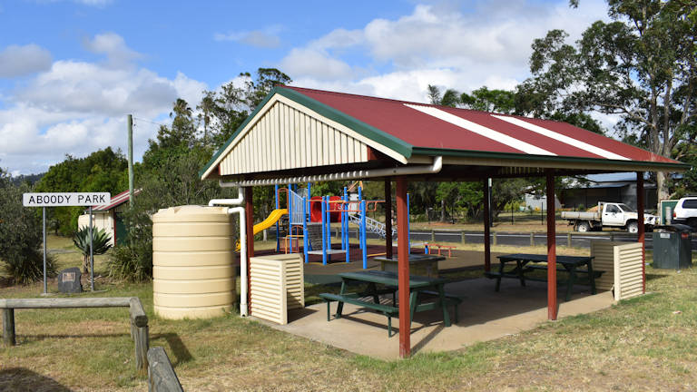 Sheltered picnic table area with free bbq and playground behind it