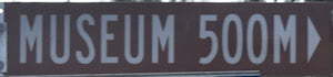 Brown sign for Museum, 500m
