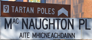 Brown sign for Tartan Poles, white sign for MacNaughton Pl, Aite Mhicneachdainn