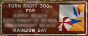 Brown sign for Rainbow Bay, turn right 300m for