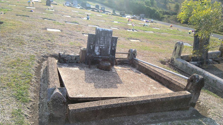 Double width grave with single central headstone in poor condition, of Charles Freeman at Tallegalla Cemetery