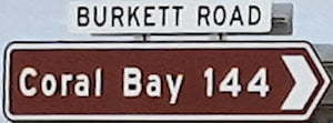 Brown sign for Coral Bay, 14km, white sign for Burkett Road