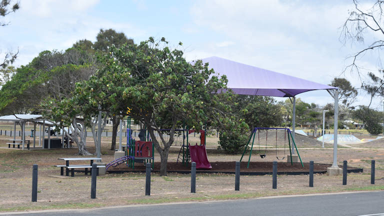 Covered playground, skate park in the background