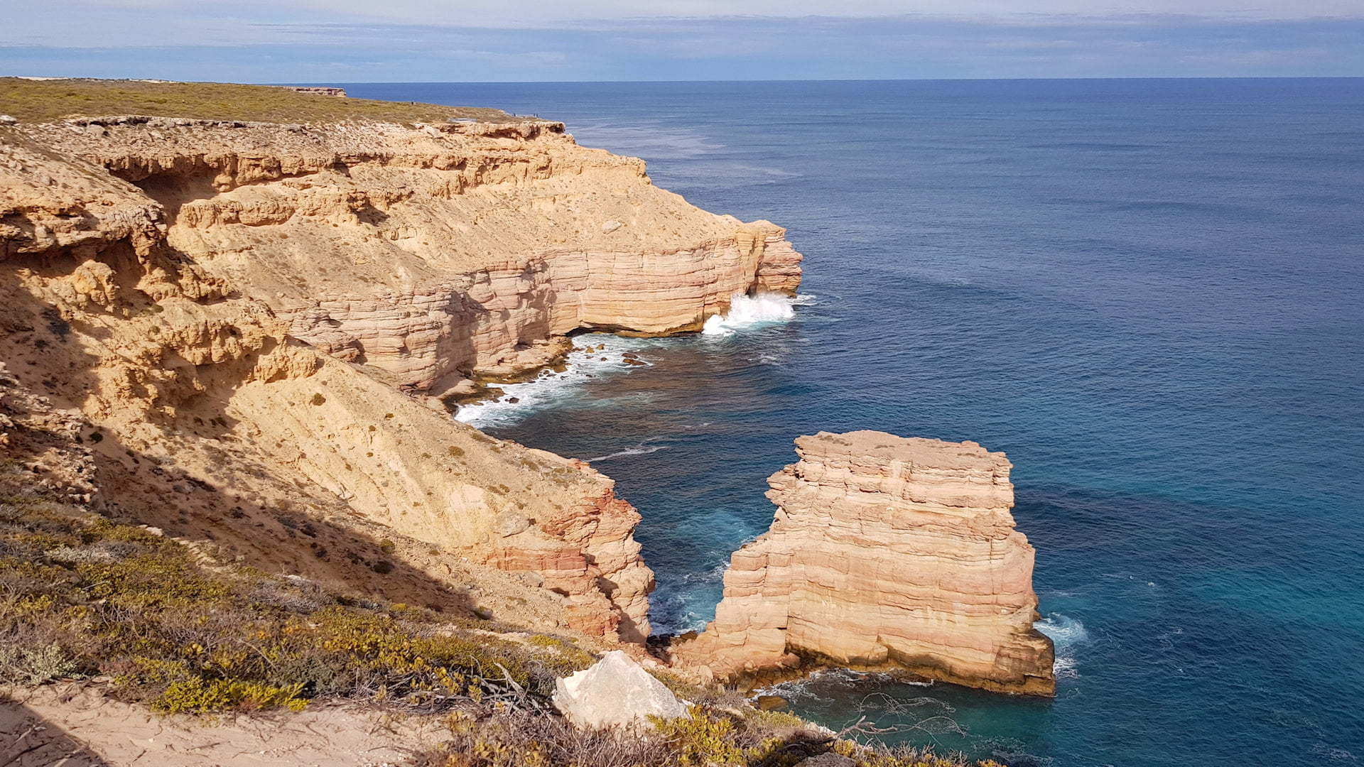Rugged sandstone coastline with a solitary rock stack off the shoreline, taken at Island Rock in Kalbarri National Park