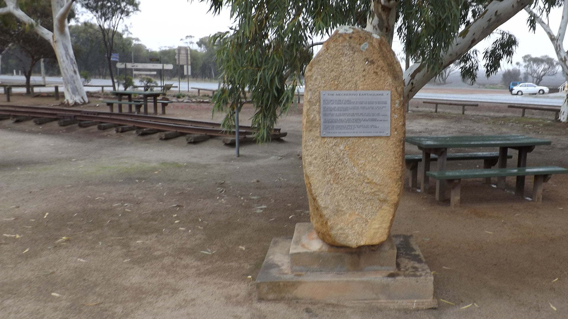 Monument at the Meckering Earthquake Display, bent railway line behind it