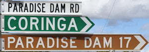Brown sign for Paradise Dam, green sign for Coringa, white sign for Paradise Dam Rd
