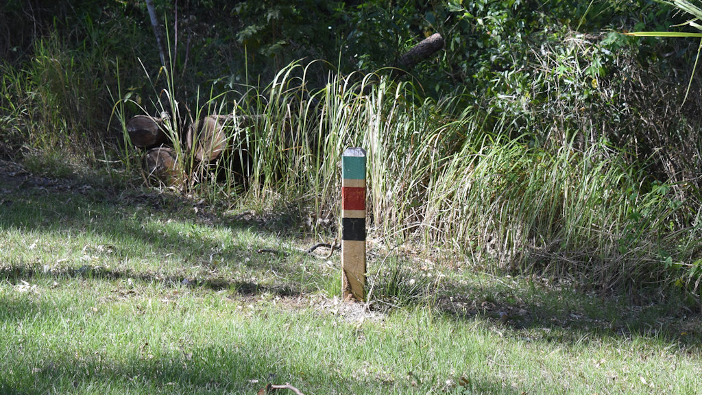 Wooden post with three coloured bands on top, green, red, black, at Pioneer Park Maryborough