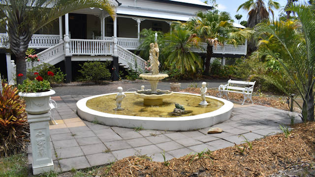Queenslander homestead house with a large water fountain at the front