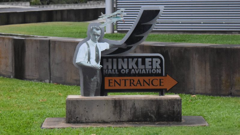Signage for the entrance to Hinkler Hall of Aviation, with an image of Hinkler and his first aircraft