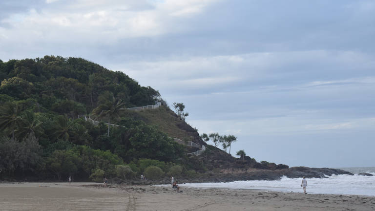 Port Douglas Headland with railings of the walking trail zig-zagging on the side, viewed from Four Mile Beach, overcast day