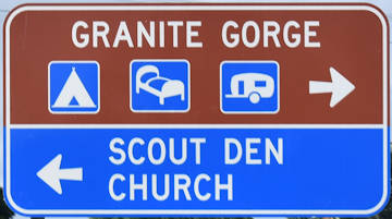 Brown sign for Granite Gorge, symbols for camping, accommodation, caravan