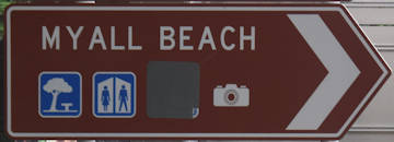 Brown sign for Myall Beach, symbols for picnic, toilets, camera