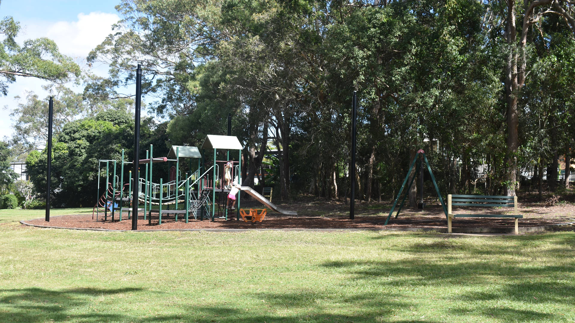 Playground in an open grass area with trees in the background, taken at Melaleuca Environmental Park near Manly Queensland
