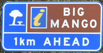 Brown sign for Big Manger, tourist information centre symbol, 1km ahead