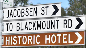Brown sign for Historic Hotel, white signs for Jacobsen St and To Blackmount Rd