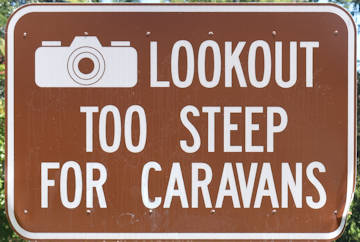 Brown sign for Lookout Too Steep for Caravans, with a camera symbol