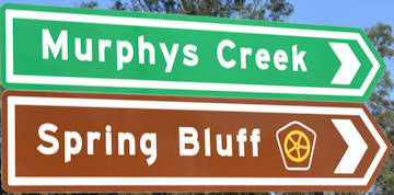 Brown sign for Spring Bluff, green sign for Murphys Creek