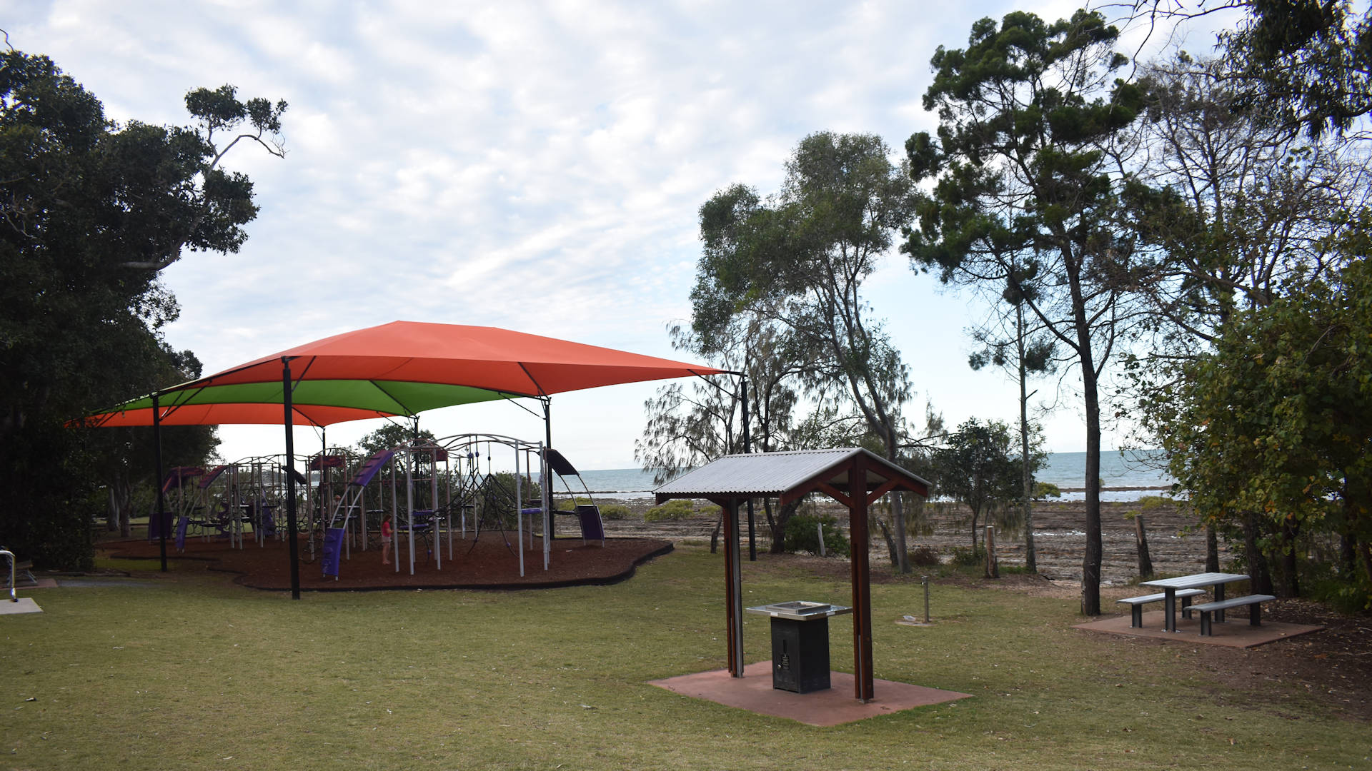 Playground, BBQ, and picnic table in a park, taken at The Pines in Hervey Bay