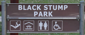 Brown sign for Black Stump Park, symbols for playground, sheltered picnic tables, toilets, disabled access