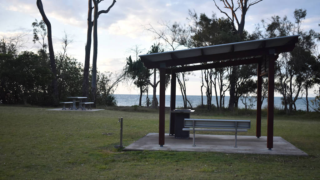 Shelter area with seating and BBQ in green space, taken at Black Stump Park in Hervey Bay