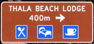 Brown sign for Thala Beach Lodge, 400m, symbols for food, beds, cafe