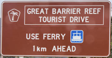 Brown sign for Great Barrier Reef Tourist Drive, Use Ferry, 1km Ahead