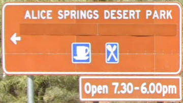 Brown sign for Alice Springs Desert Park, Open 7.30-6.00, blue symbols for cafe and restaurant