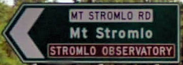 Brown sign for Stromlo Observatory, green sign for Mt Stromlo, white sign for Mt Stromlo Rd