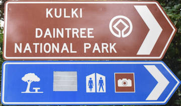 Brown sign for Kulki, Daintree National Park, blue symbols for shaded seating, toilets, lookout