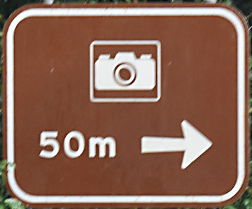 Brown sign for a lookout with camera symbol, 50m