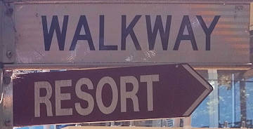 Brown sign for Resort, white sign for Walkway