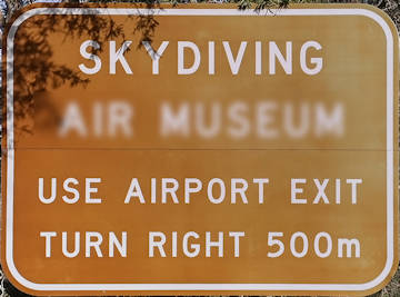 Brown sign for Skydiving, use airport exit, turn right 500m
