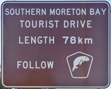 Brown sign for Southern Moreton Bay Tourist Drive, Length 78km, follow tourist drive symbol of dugong