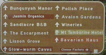 Brown sign for Bungunyah Manor, Jasmin Organics, Sandiacre B&B, The Escarpment, Lisson Grove, Glow-worm Caves, Polish Place, Avalon Gardens, Wineries, Mt Tamborine Motel, Bavarian Haus, Cheese Factory