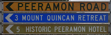 Brown sign for Historic Peeramon Hotel, yellow sign for Peeramon Road