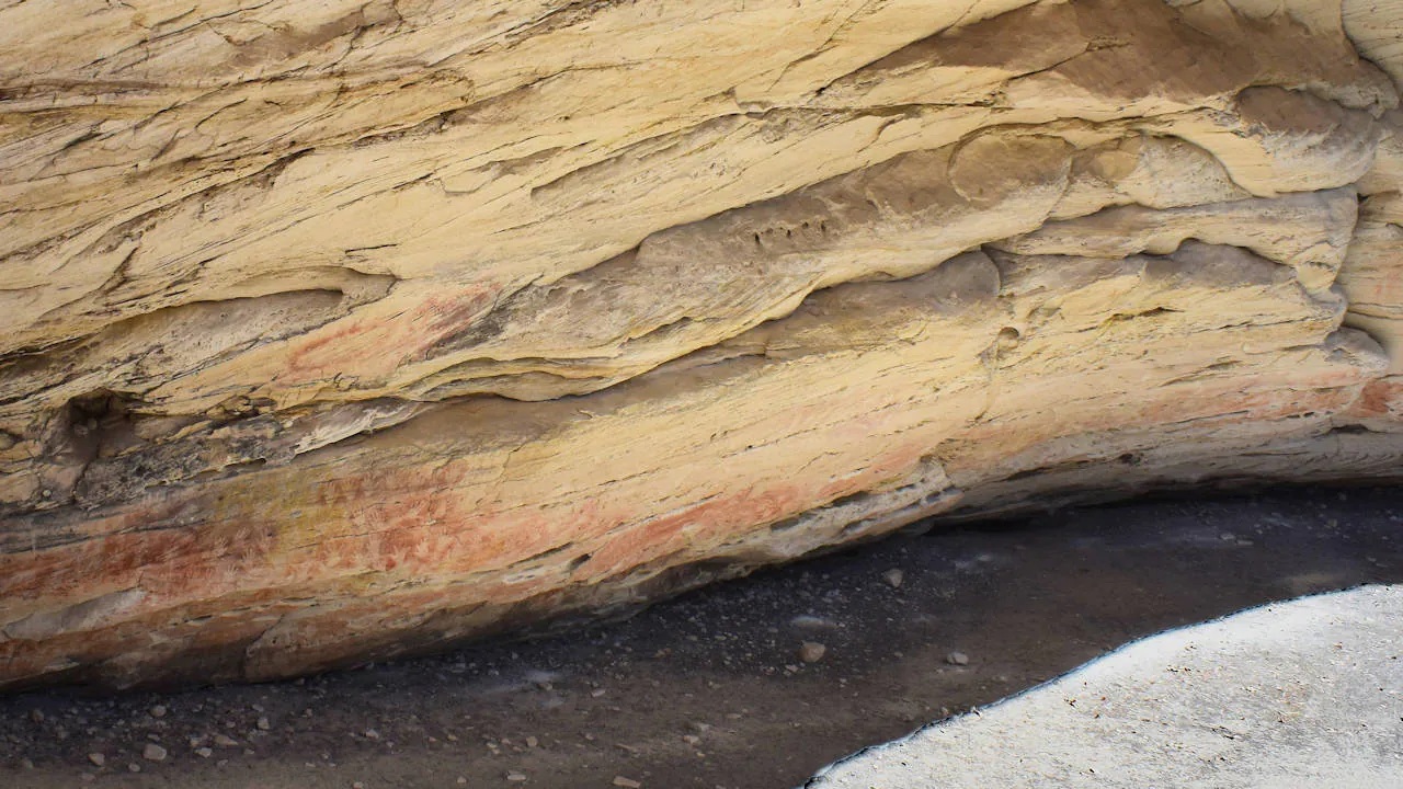 Aboriginal art paintings at the bottom of a sandstone cave wall, taken at The Cathedral in Carnarvon Gorge